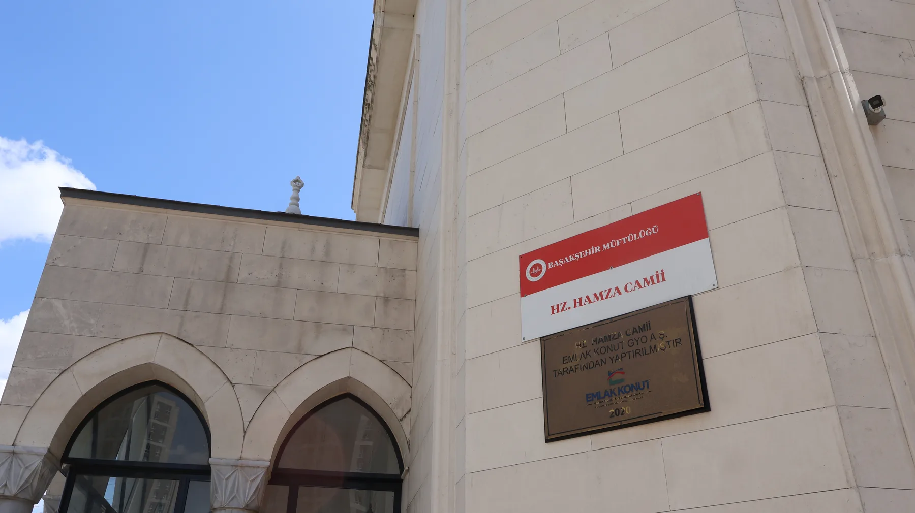 Kuzey duvarındaki Başakşehir Müftülüğü tabelasında HZ. HAMZA CAMİİ yazıyor. Altındaki pirinç plaket, yapının 2020 yılında Emlak Konut GYO tarafından yaptırıldığını belirtiyor.